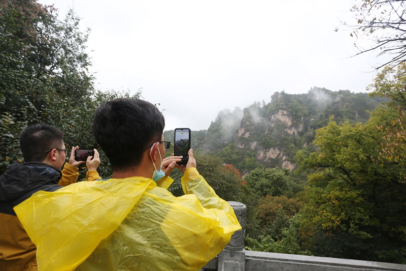 09——10月4日，游客在甘肃省平凉市崆峒山上欣赏、拍摄雨景。