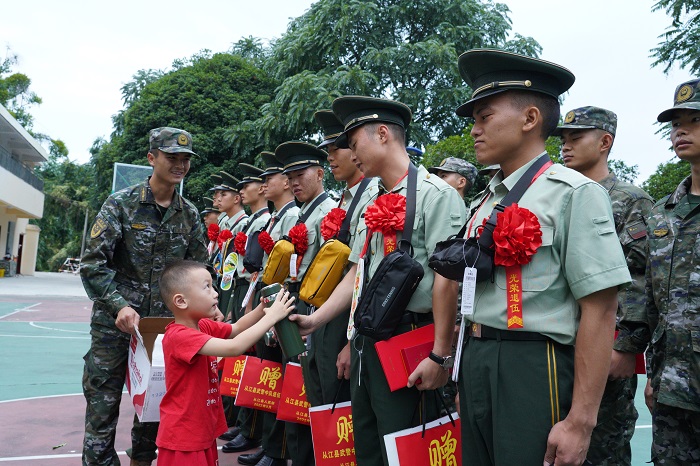 图为  拥军小朋友向退役士兵赠送保温杯现场（韦阳慧  摄影）