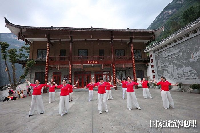 图11：游客在下庄“牢记使命”纪念馆前载歌载舞庆祝下庄人在新时代奋进新征程的丰功佳绩。2023年5月20日，摄于重庆巫山下庄。唐金生摄